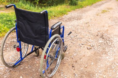 Yoldaki boş tekerlekli sandalye hasta hizmetlerini bekliyor. Dışarıda park etmiş engelli insanlar için tekerlekli sandalye. Özürlü insanlar için erişilebilir. Sağlık hizmeti tıbbi konsepti.