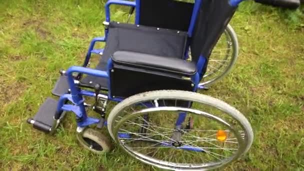 Empty wheelchair standing in hospital park waiting for patient services. Wheel chair for person with disability parked outdoor. Accessible for person with disability. Health care medical concept. — Stock Video