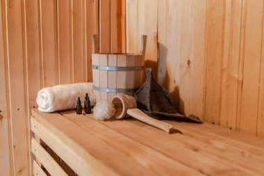 Geleneksel eski Rus hamamı SPA konsepti. Finlandiya sauna saunasında geleneksel sauna aksesuarları ve havlunun aromalı yağ kepçesi kullanılmış. Rahatlayın köy banyosu konsepti.