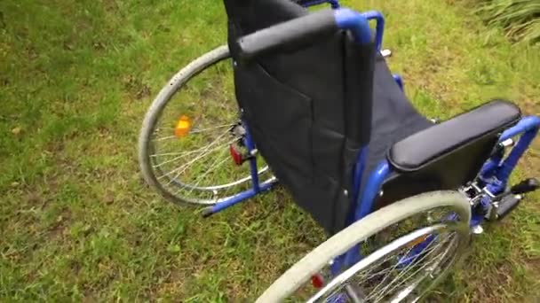 Pusty wózek inwalidzki stojący w parku szpitalnym i czekający na usługi dla pacjentów. Krzesełko dla osób niepełnosprawnych zaparkowane na zewnątrz. Dostępny dla osób niepełnosprawnych. Koncepcja medyczna opieki zdrowotnej. — Wideo stockowe