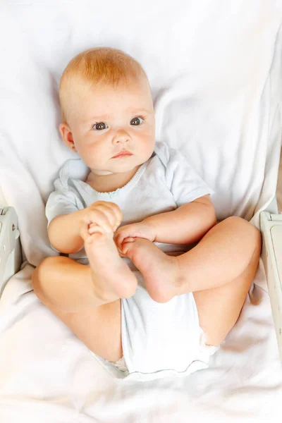 하얀 배경에 카메라를 보고 있는 귀여운 신생아. 아기는 집 침대에 누운 채 휴식을 취한다. 어머니의 행복 한 자녀 개념. — 스톡 사진