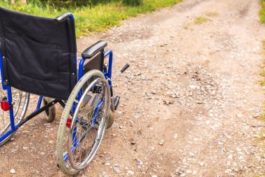 Yoldaki boş tekerlekli sandalye hasta hizmetlerini bekliyor. Dışarıda park etmiş engelli insanlar için tekerlekli sandalye. Özürlü insanlar için erişilebilir. Sağlık hizmeti tıbbi konsepti.