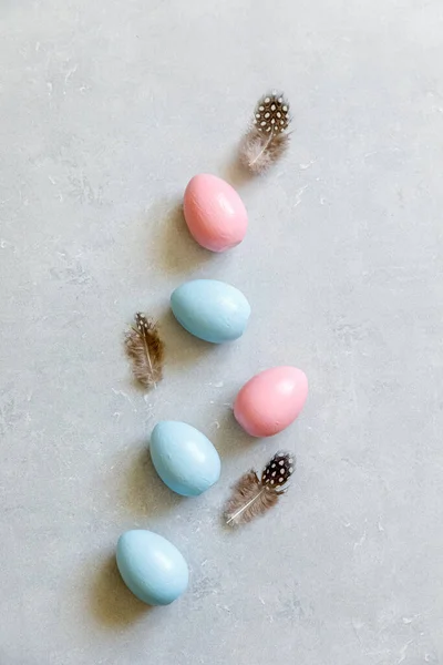 Feliz concepto de Pascua. Preparación para las vacaciones. Pluma dorada de huevos de Pascua decorada sobre fondo gris piedra de hormigón. Minimalismo simple plano laico vista superior copia espacio. — Foto de Stock