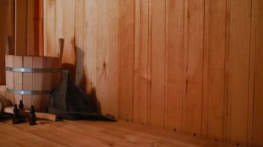 Geleneksel eski Rus hamamı SPA konsepti. Finlandiya sauna saunasında geleneksel sauna aksesuarları ve havlunun aromalı yağ kepçesi kullanılmış. Rahatlayın köy banyosu konsepti.