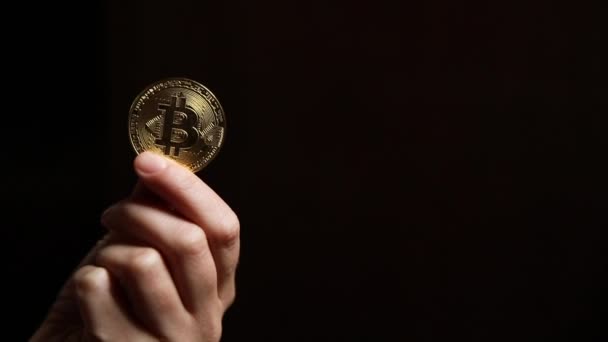 Γυναίκα χέρι κρατώντας cryptocurrency χρυσό bitcoin σε σκούρο φόντο. Ηλεκτρονικό εικονικό χρήμα για web banking και διεθνείς πληρωμές δικτύου. Σύμβολο του κρυπτογραφημένου εικονικού νομίσματος. Έννοια εξόρυξης. — Αρχείο Βίντεο