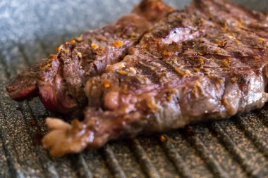 Profesyonel mutfakta ızgarada pişen etli biftek. Izgarada kızarmış biftek. Lezzetli, modern mutfak.