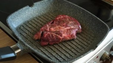 Profesyonel mutfakta ızgarada pişen etli biftek. Izgarada kızarmış biftek. Lezzetli, modern mutfak.