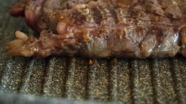 Profesyonel mutfakta ızgarada pişen etli biftek. Izgarada kızarmış biftek. Lezzetli, modern mutfak.