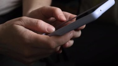 Cep telefonu tutan kadın uygulamayı kullanarak ekran parşömen sayfasına dokunuyor. Akıllı telefon cep telefonu aygıtı ellerinde. İnternet haber içeriği uygulamaları cep telefonu bağımlılığı kavramı