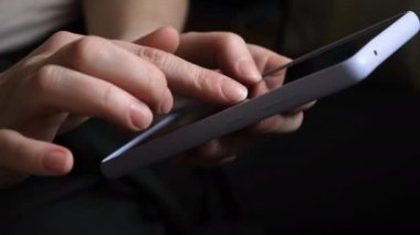 Cep telefonu tutan kadın uygulamayı kullanarak ekran parşömen sayfasına dokunuyor. Akıllı telefon cep telefonu aygıtı ellerinde. İnternet haber içeriği uygulamaları cep telefonu bağımlılığı kavramı