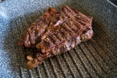 Profesyonel mutfakta ızgarada pişen etli biftek. Izgarada kızarmış biftek. Lezzetli, modern mutfak.