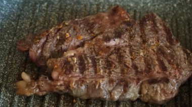Profesyonel mutfakta ızgarada pişen etli biftek. Izgarada kızarmış biftek. Lezzetli, modern mutfak.