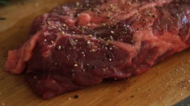 Biber sarımsaklı sulu et ve biberiye mutfakta ahşap kesme tahtasında pişirmeye hazır. Pişmemiş çiğ biftek ve sarımsak. Enfes, modern mutfağı kapatın.