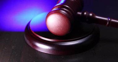 Hukuk teması. Mahkeme duruşması başlamıştır. Yargıç Tokmak, ahşap masada, polis acil durum ışığı ile. Karanlık arka planda yargıç tokmağı. Adalet insan hakları kavramı
