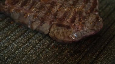 Profesyonel mutfakta ızgarada pişen etli biftek. Izgarada kızarmış biftek. Lezzetli, modern mutfak.