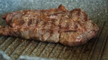 Profesyonel mutfakta ızgarada pişen etli biftek. Izgarada kızarmış biftek. Lezzetli, modern mutfak.