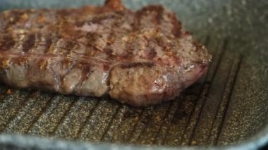 Profesyonel mutfakta ızgarada pişen etli biftek. Izgarada kızarmış biftek. Lezzetli, modern mutfak.