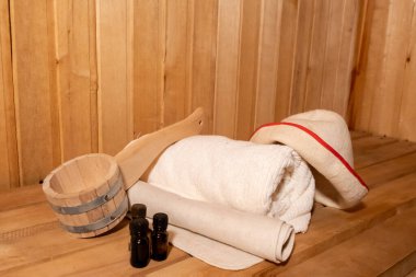 Geleneksel eski Rus hamamı SPA konsepti. Finlandiya sauna saunasında geleneksel sauna aksesuarları ve havlunun aromalı yağ kepçesi kullanılmış. Rahatlayın köy banyosu konsepti