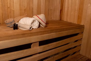 Geleneksel eski Rus hamamı SPA konsepti. Finlandiya sauna saunasında geleneksel sauna aksesuarları ve havlunun aromalı yağ kepçesi kullanılmış. Rahatlayın köy banyosu konsepti