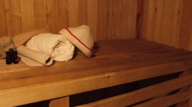Geleneksel eski Rus hamamı SPA konsepti. Finlandiya sauna saunasında geleneksel sauna aksesuarları ve havlunun aromalı yağ kepçesi kullanılmış. Rahatlayın köy banyosu konsepti