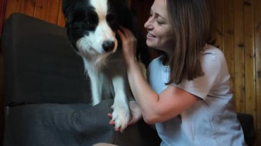 Gülümseyen genç bir kadın evdeki kanepede köpek yavrusu çoban köpeğiyle oynuyordu. Evcil köpek arkadaşı olan ev sahibi kız evde dinleniyor. İnsan ve hayvan arkadaşlığı kavramı