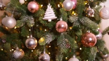 Klasik yeni yıl ağacı, gümüş, beyaz, pembe süsleme oyuncakları, top ve çözünmüş çelenk ışıklarıyla süslenmiş. Modern klasik tatil tasarımı. Evde Noel arifesi