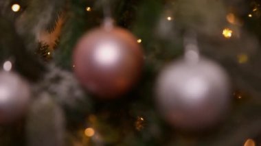 Klasik yeni yıl ağacı, gümüş pembe süslemelerle süslenmiş oyuncak ve top ve çözülmüş çelenk ışıklarıyla süslenmiş. Modern klasik tatil tasarımı. Evde Noel arifesi