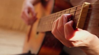 Kadın elleri klasik akustik gitar çalıyor, yakın plan. Müzik konsepti. Kız şarkı çalmayı ve şarkı yazmayı öğreniyor. Canlı müzik. Müzik festivali. Hobi aracı, boş zaman eğitimini gevşetin