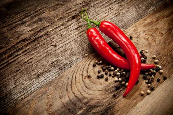 Red hot chili peppers on old wooden table — Stock Photo, Image