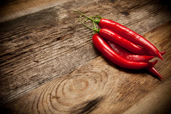 Pimientos rojos picantes en mesa de madera vieja —  Fotos de Stock