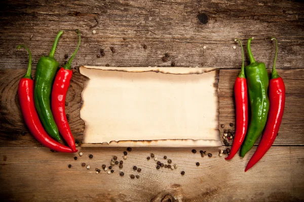 Red hot chili papričky s starý list papíru — Stock fotografie