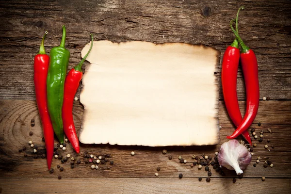 Rote Chilischoten mit dem alten Blatt Papier — Stockfoto