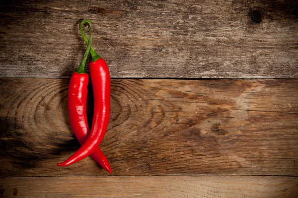 Red hot chili peppers on old wooden table Royalty Free Stock Images