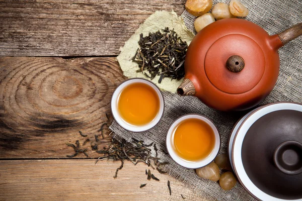 Teetassen mit Teekanne auf altem Holztisch — Stockfoto