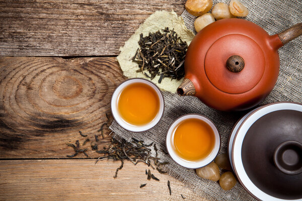 Tea cups with teapot on old wooden table