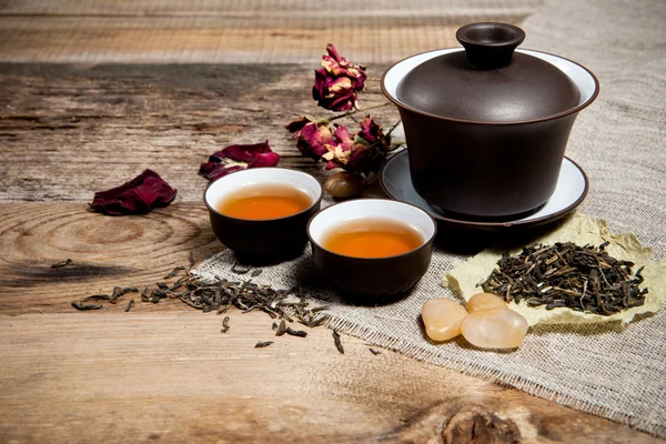 Teetassen mit Teekanne auf altem Holztisch — Stockfoto