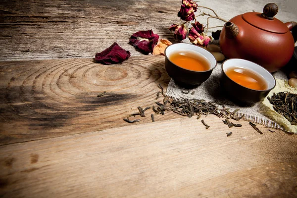 Чашки чая с чайником на старом деревянном столе — стоковое фото