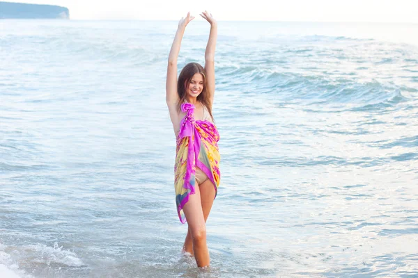 Mujer joven en un pareo en el mar —  Fotos de Stock