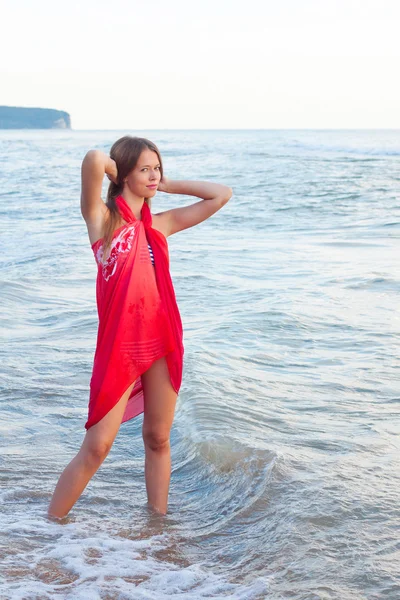 Jonge vrouw in een pareo op de zee — Stockfoto