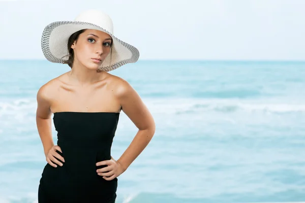 Jolie jeune femme tenant son chapeau sur sa tête — Photo