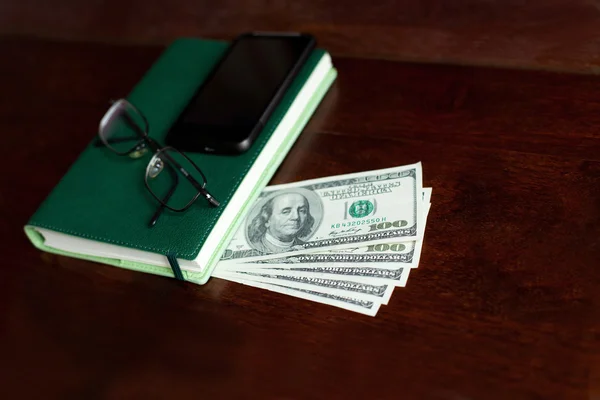 Stacks of one hundred dollars banknotes in notebook — Stock Photo, Image