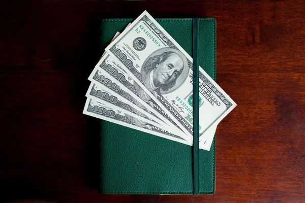 Stacks of one hundred dollars banknotes in notebook — Stock Photo, Image