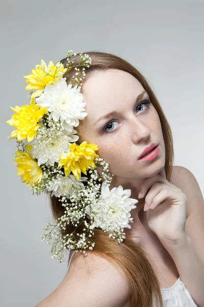 Ung kvinna med blommor i ett hår — Stockfoto