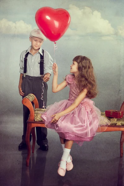 The boy gives a balloon to the girl