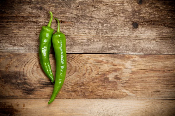 Rote Chilischoten auf altem Holztisch — Stockfoto