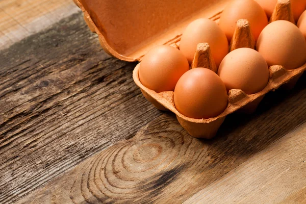 Uova nella confezione su tavolo di legno — Foto Stock