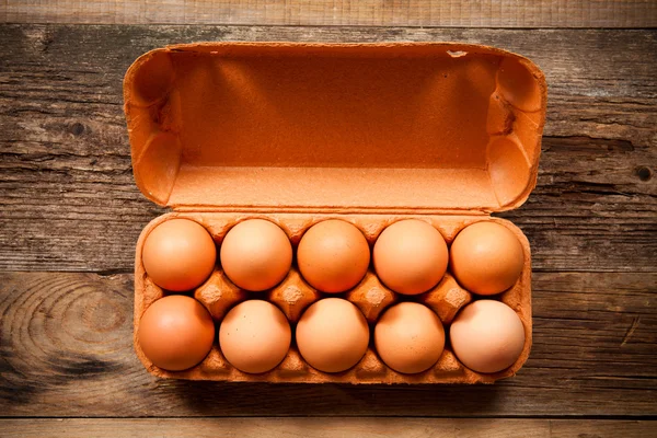 Яйца в упаковке на деревянном столе — стоковое фото