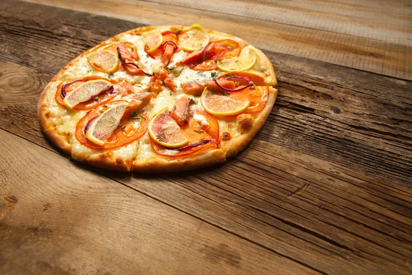 Pizza de salmón sobre mesa de madera . — Foto de Stock