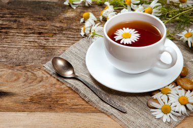 eski ahşap masa üzerinde papatya ile bitkisel çay
