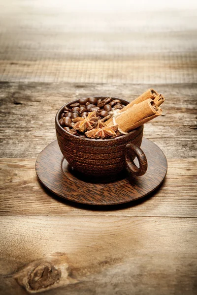 Tazza di legno con chicchi di caffè sul tavolo di legno — Foto Stock